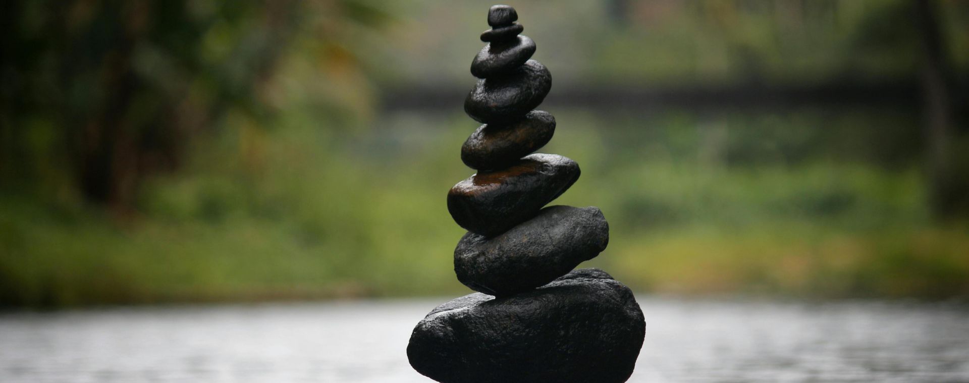 Balanced stones in a serene river evoke a sense of peace and tranquility.